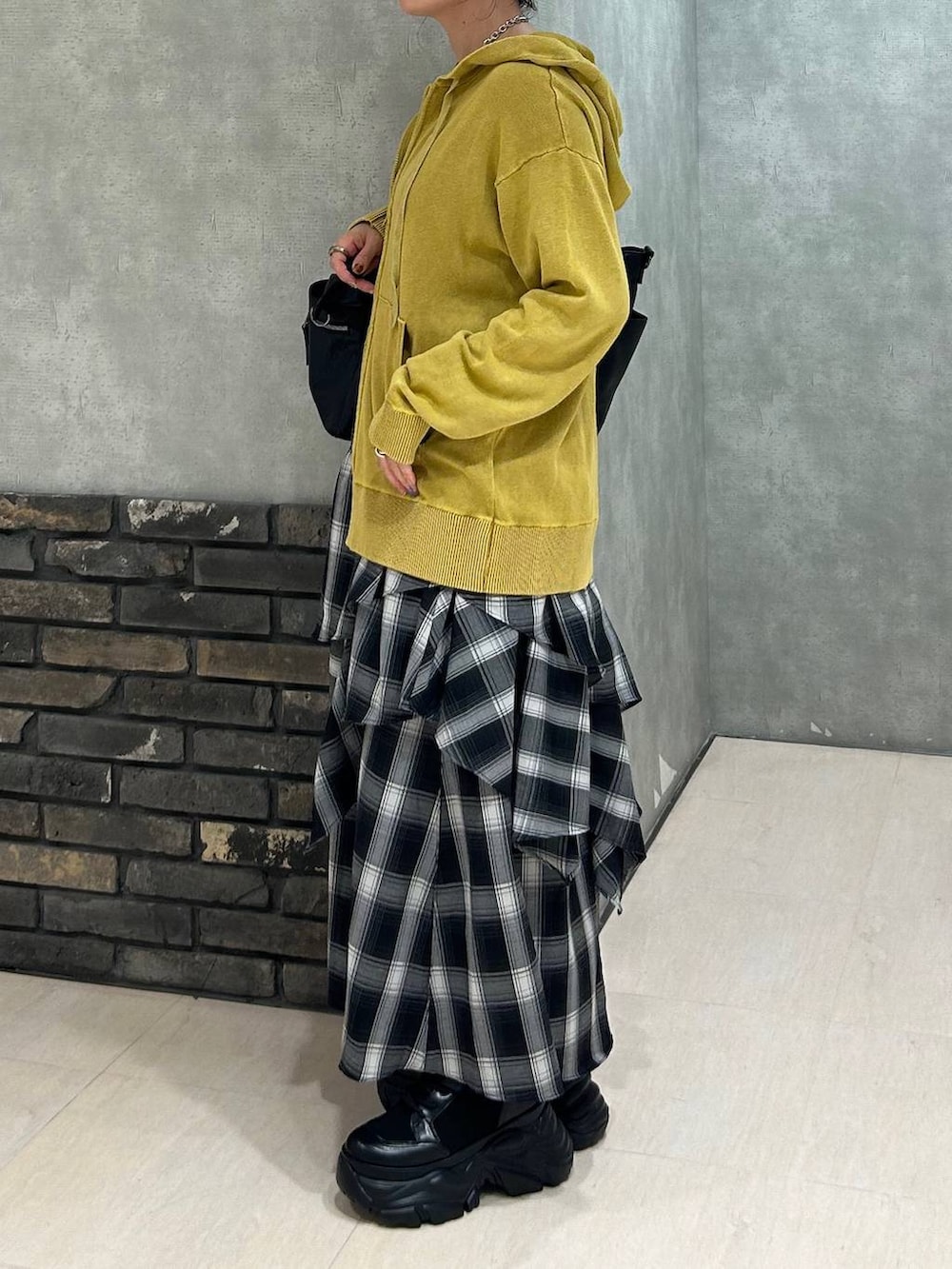 ブラック系のブーツ、ブラック系のキャミソール、ブラック系のボストンバッグを着用したレディースの秋コーディネートの6枚目の写真