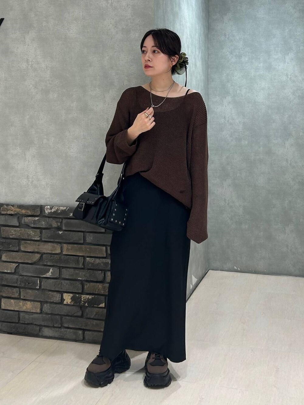 ブラウン系のブーツ、ブラック系のキャミソール、ブラウン系のニット/セーターを着用したレディースの秋コーディネートの3枚目の写真