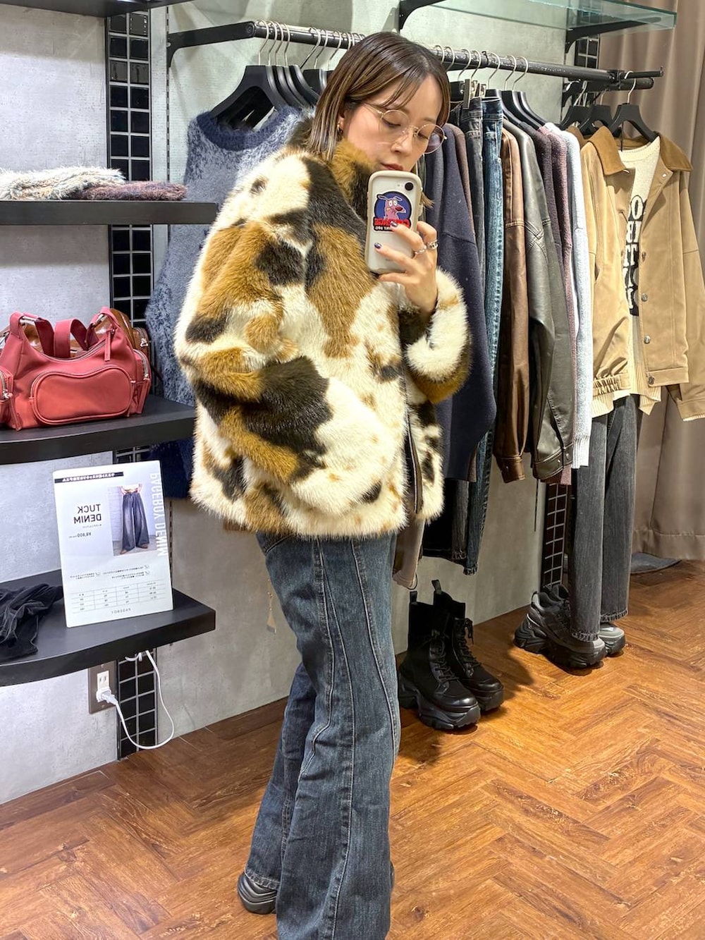 ブラック系のスニーカー、ブルー系のデニムパンツ、ブラウン系のブルゾンを着用したレディースの秋コーディネートの4枚目の写真