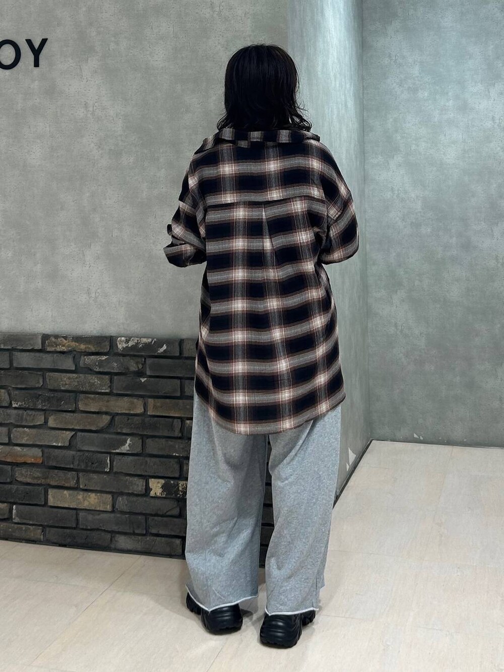 ブラック系のスニーカー、グレー系のスウェットパンツ、ブラウン系のシャツ/ブラウスを着用したレディースの秋コーディネートの5枚目の写真