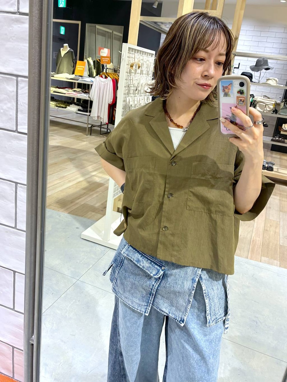 ブルー系のデニムパンツ、ブルー系のベルト、イエロー系のネックレスを着用したレディースの春コーディネートの3枚目の写真