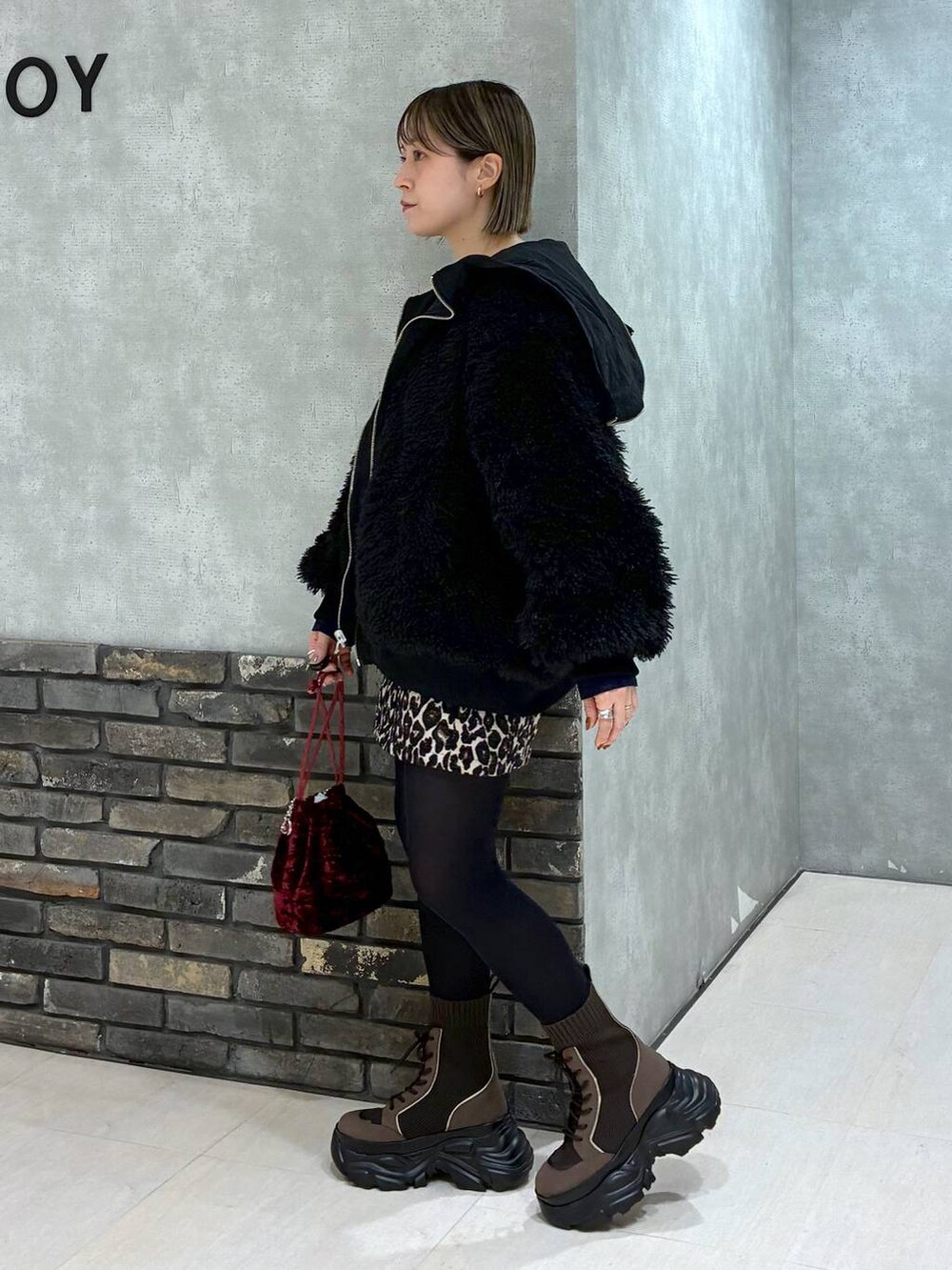 ブラウン系のブーツ、ブラック系のブルゾン、ブラウン系のスカートを着用したレディースの冬コーディネートの3枚目の写真