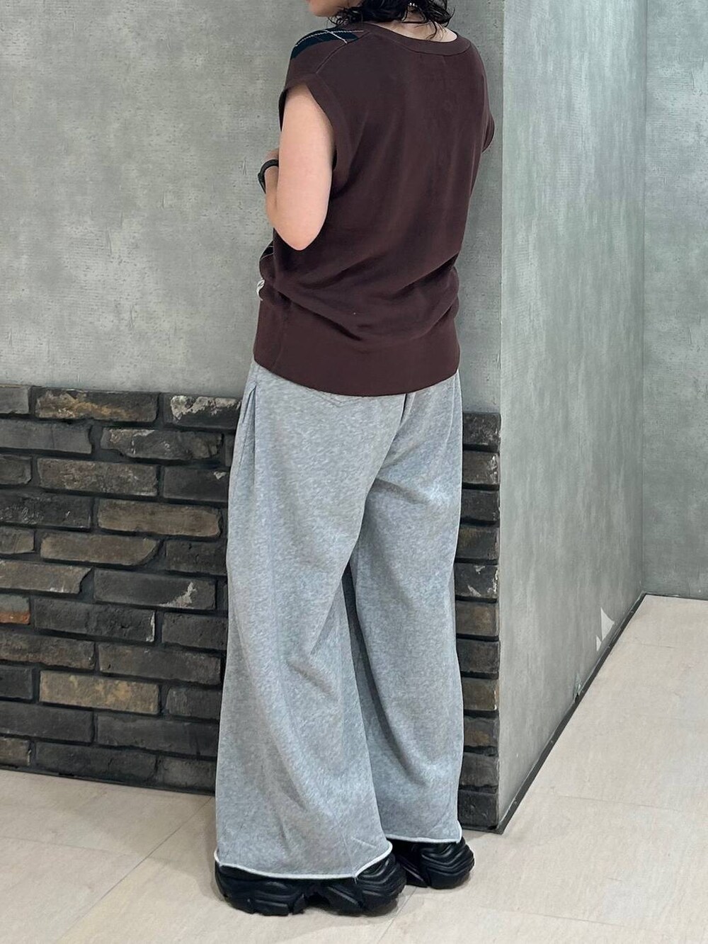 ブラック系のスニーカー、ブラック系のキャミソール、グレー系のスウェットパンツを着用したレディースの秋コーディネートの4枚目の写真