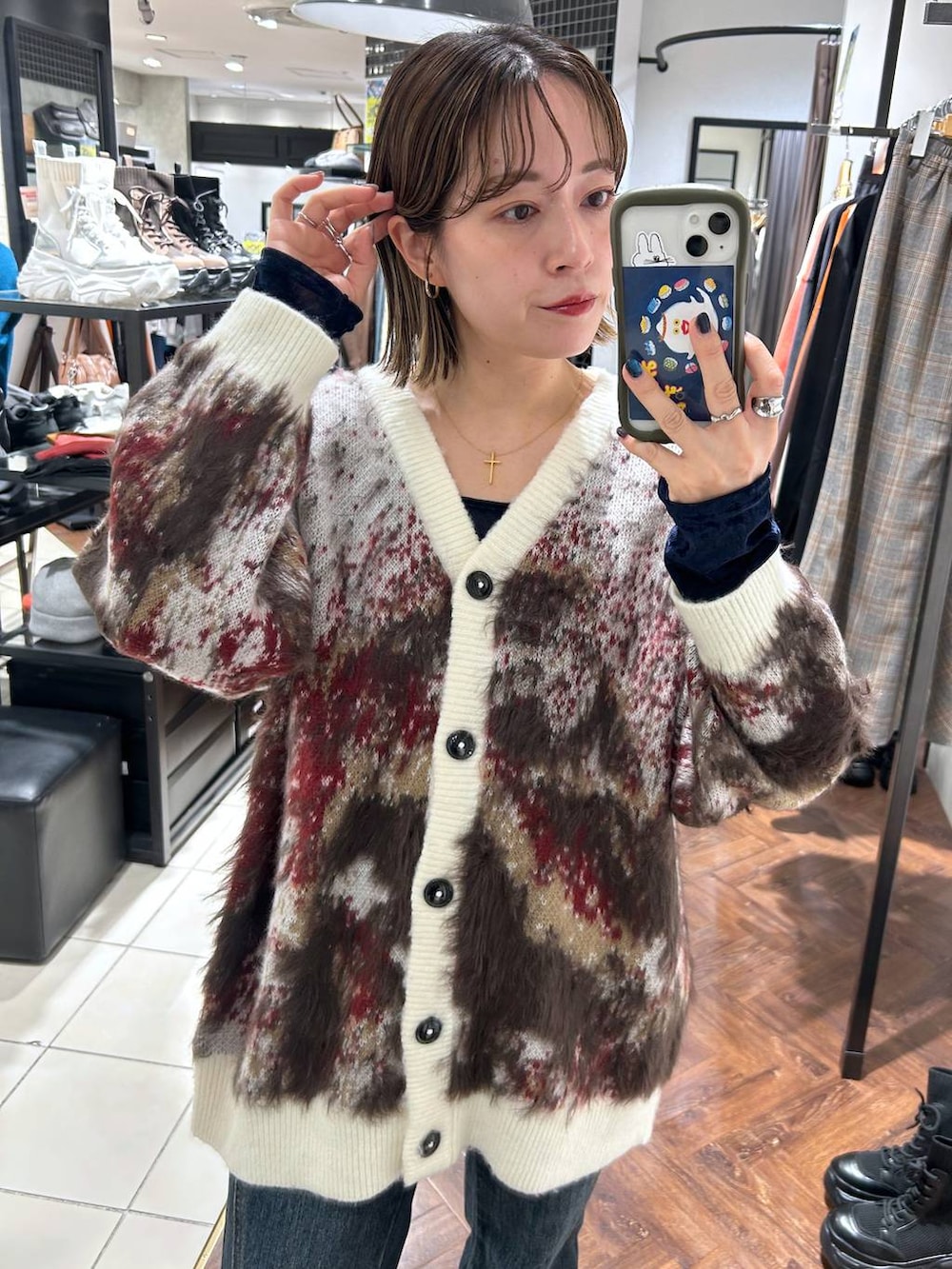 ブラック系のスニーカー、ブルー系のデニムパンツ、ホワイト系のカーディガン/ボレロを着用したレディースの秋コーディネートの3枚目の写真