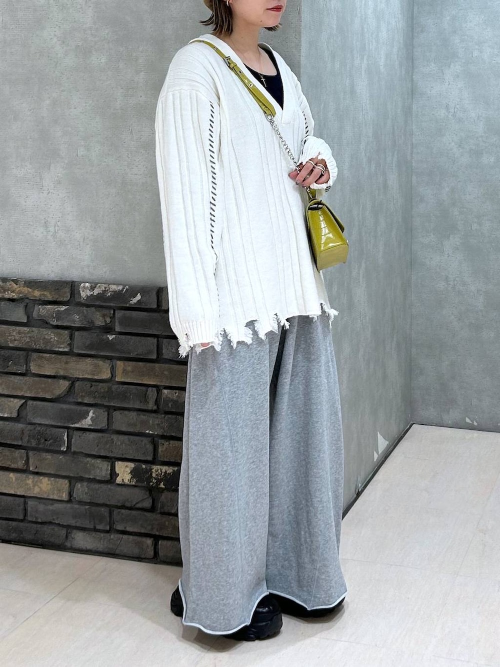 ブラック系のスニーカー、グレー系のスウェットパンツ、イエロー系のハンドバッグを着用したレディースの秋コーディネートの5枚目の写真