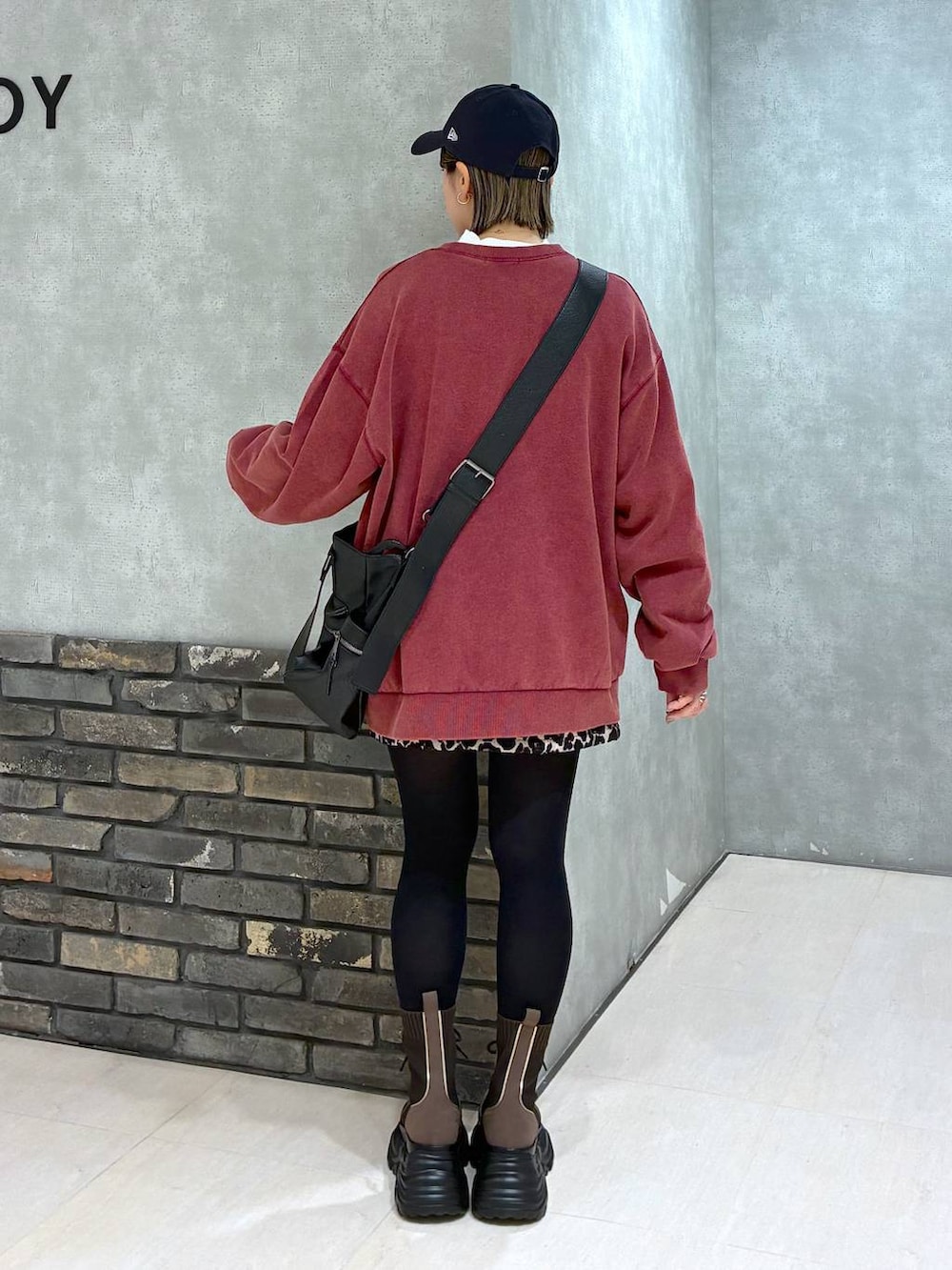 ブラウン系のブーツ、ブラック系のボストンバッグ、レッド系のスウェットを着用したレディースの冬コーディネートの6枚目の写真