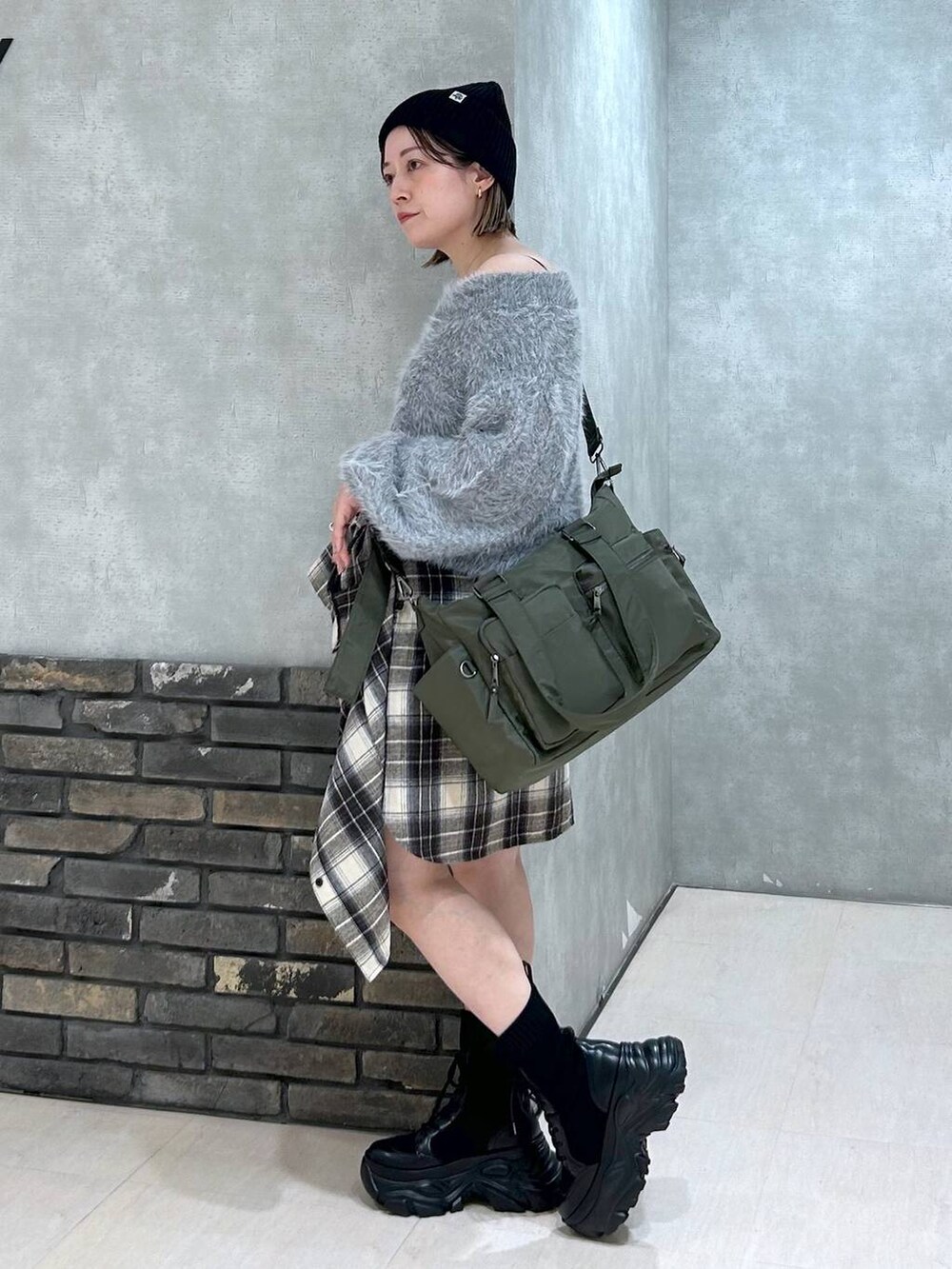 ブラック系のブーツ、グリーン系のボストンバッグ、ブラック系のその他パンツを着用したレディースの秋コーディネートの5枚目の写真