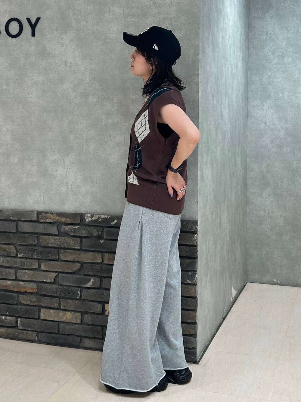 ブラック系のスニーカー、ブラック系のキャミソール、グレー系のスウェットパンツを着用したレディースの秋コーディネートの3枚目の写真