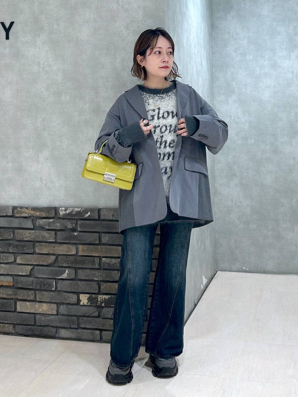 グレー系のスニーカー、ブルー系のデニムパンツ、グレー系のテーラードジャケットを着用したレディースの秋コーディネートの4枚目の写真