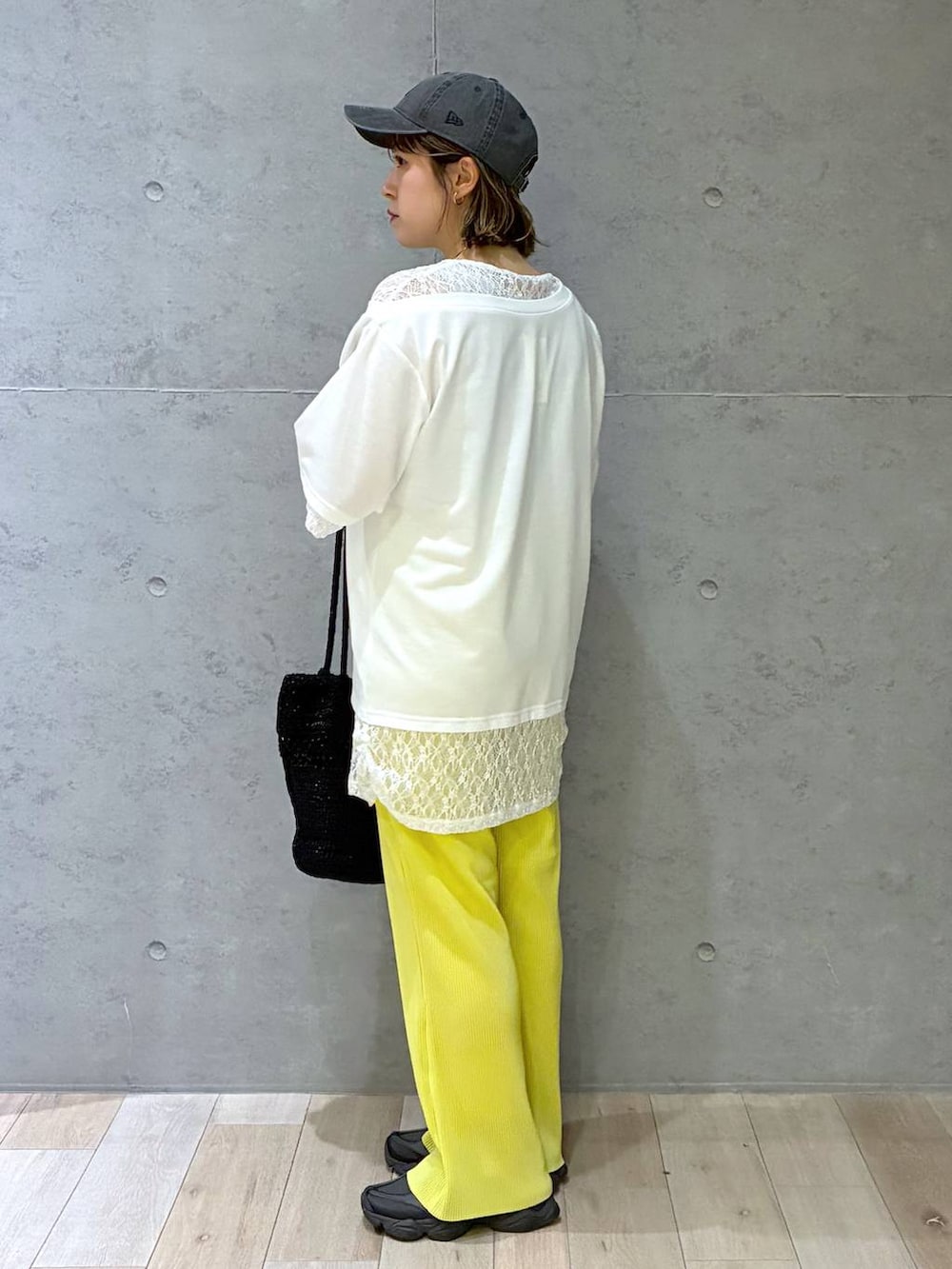 イエロー系のその他パンツ、ブラック系のショルダーバッグ、ホワイト系のTシャツ/カットソーを着用したレディースの春コーディネートの4枚目の写真