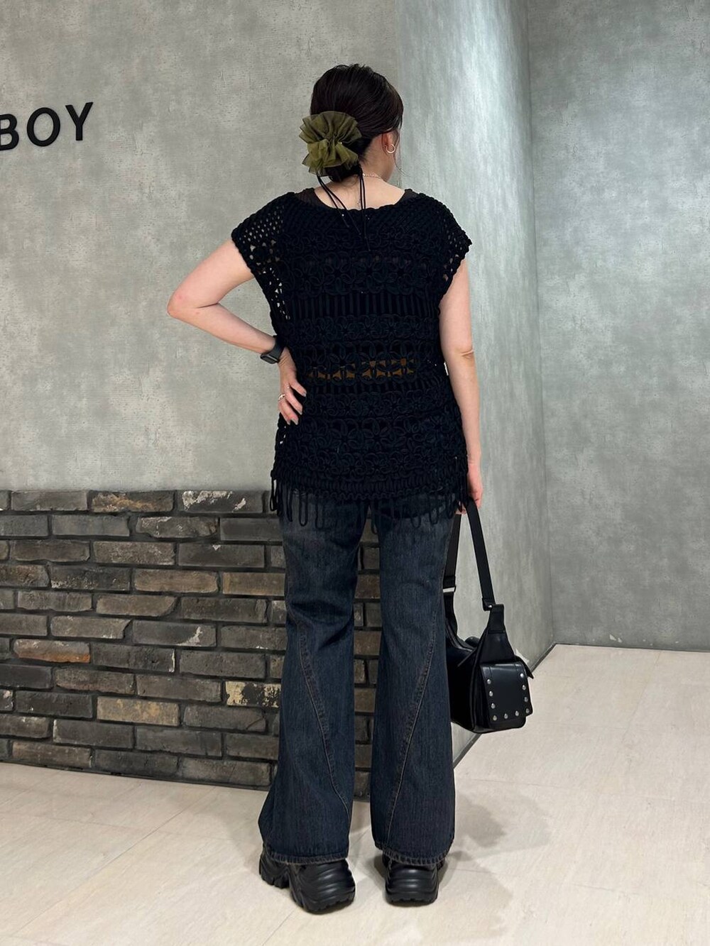 ブラック系のスニーカー、グレー系のタンクトップ、ブルー系のデニムパンツを着用したレディースの夏コーディネートの3枚目の写真