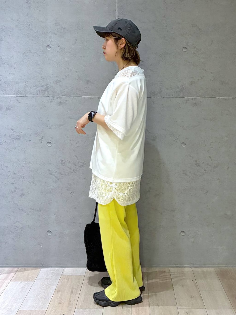 イエロー系のその他パンツ、ブラック系のショルダーバッグ、ホワイト系のTシャツ/カットソーを着用したレディースの春コーディネートの3枚目の写真