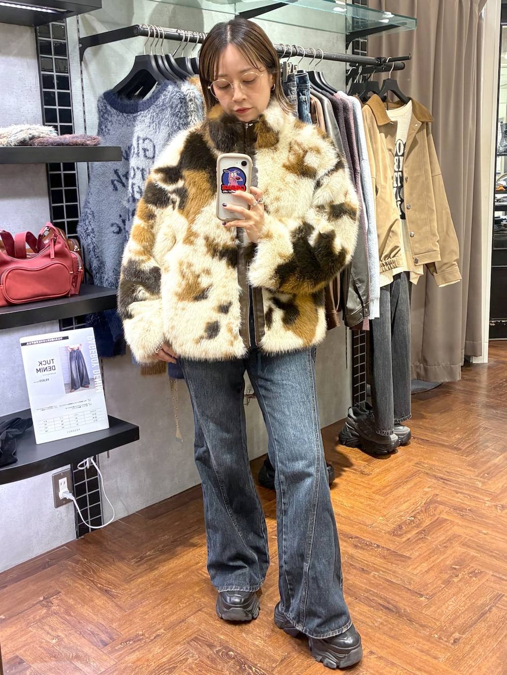 ブラック系のスニーカー、ブルー系のデニムパンツ、ブラウン系のブルゾンを着用したレディースの秋コーディネートの3枚目の写真