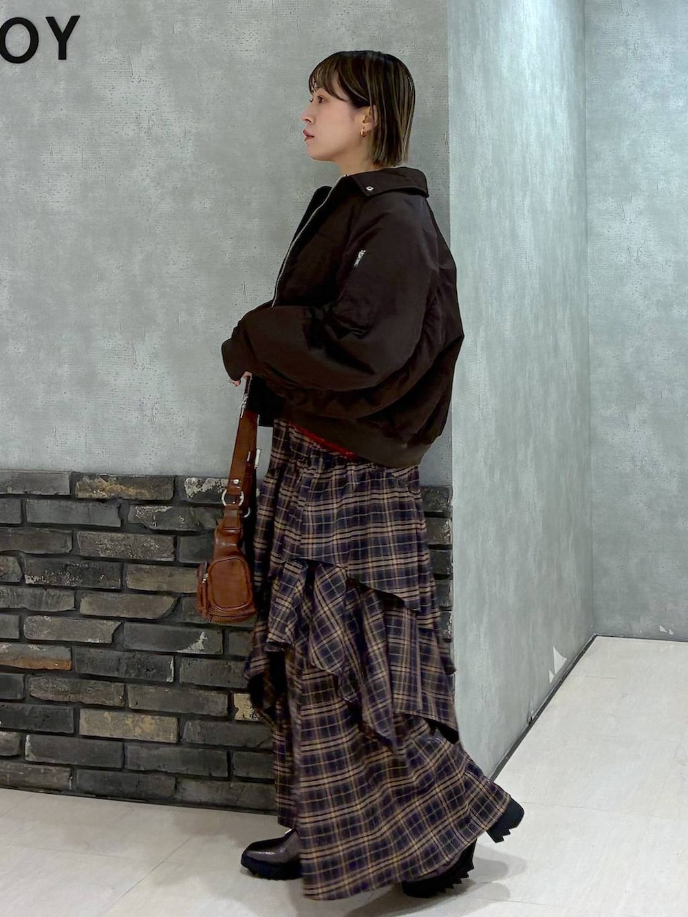 その他のブーツ、ブラウン系のスカート、ブラウン系のショルダーバッグを着用したレディースの冬コーディネートの8枚目の写真