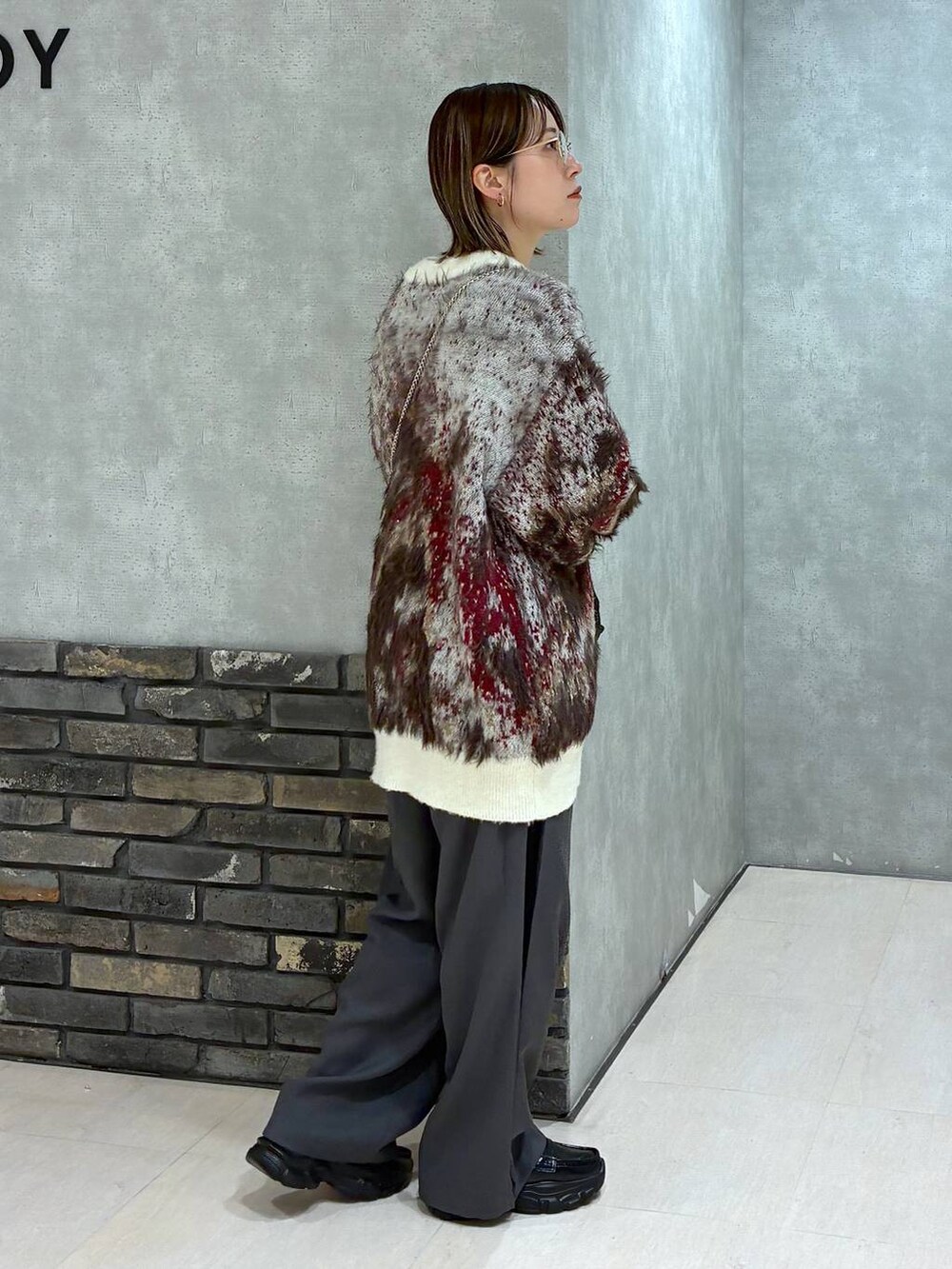 ホワイト系のTシャツ/カットソー、ホワイト系のカーディガン/ボレロ、グレー系のスラックスを着用したレディースの秋コーディネートの2枚目の写真