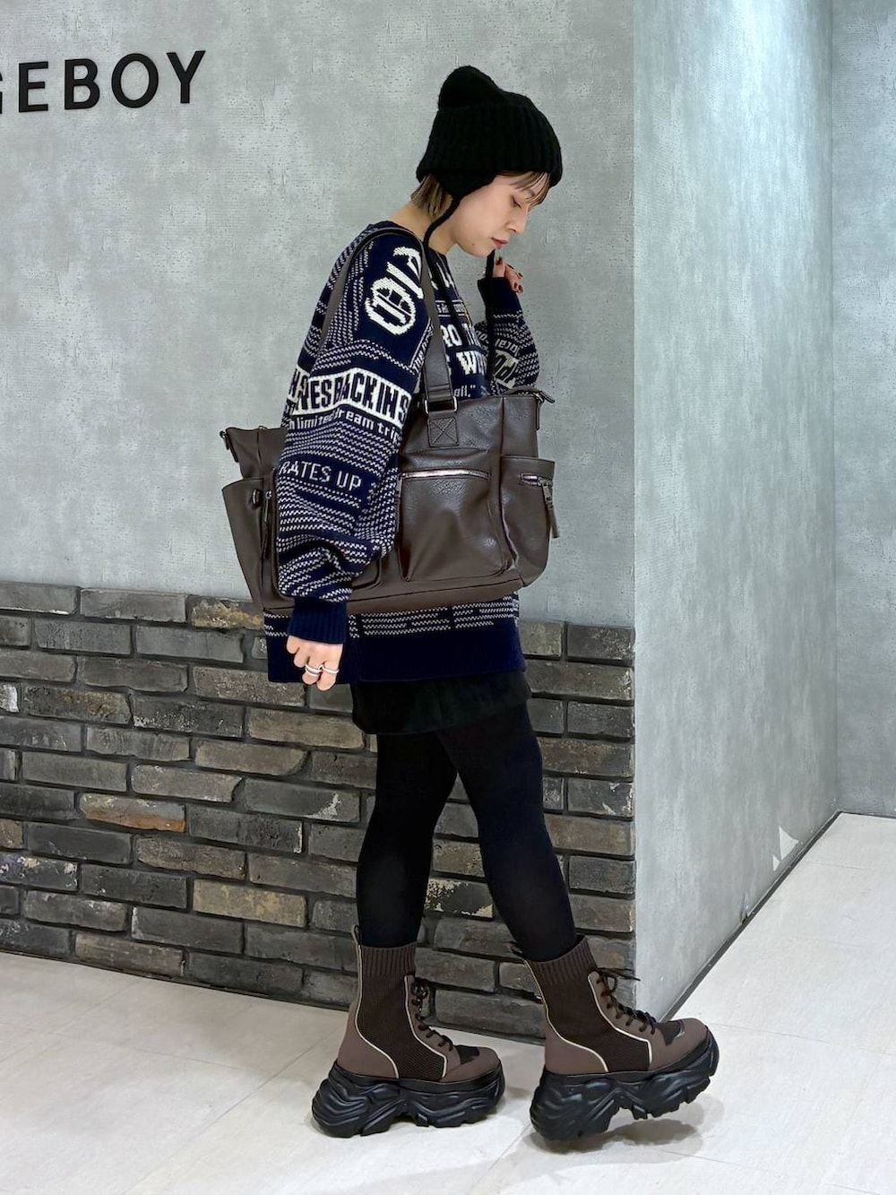 ブラウン系のブーツ、ブラウン系のボストンバッグ、ブラック系のスカートを着用したレディースの冬コーディネートの4枚目の写真