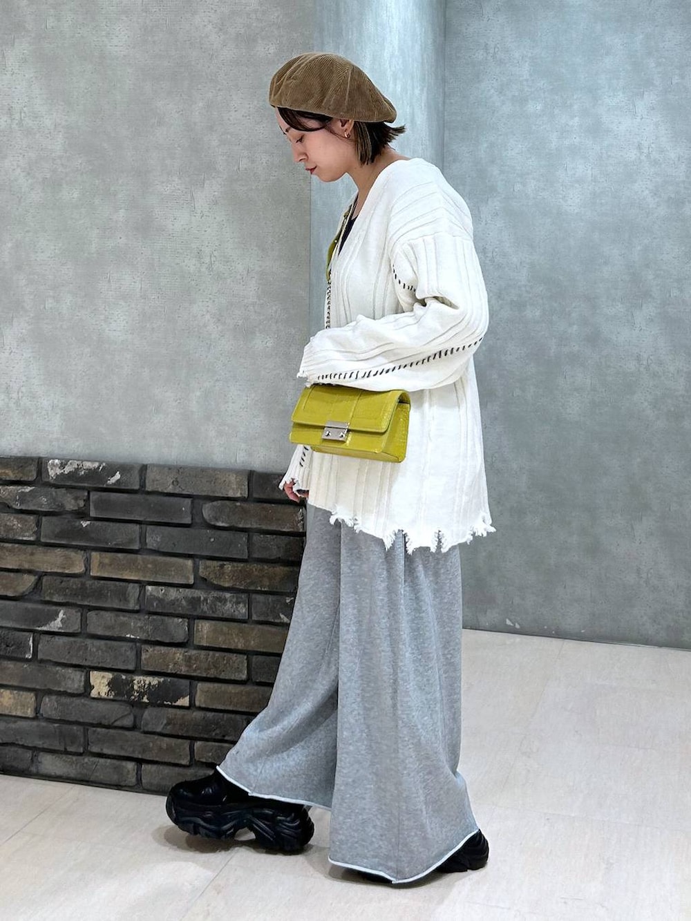 ブラック系のスニーカー、グレー系のスウェットパンツ、イエロー系のハンドバッグを着用したレディースの秋コーディネートの7枚目の写真