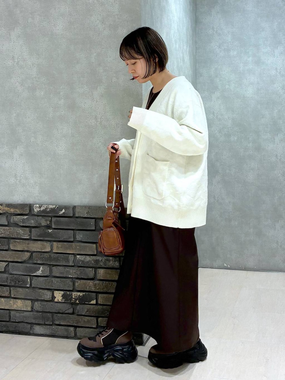 ブラウン系のブーツ、ブラウン系のニット/セーター、ブラウン系のスカートを着用したレディースの冬コーディネートの5枚目の写真