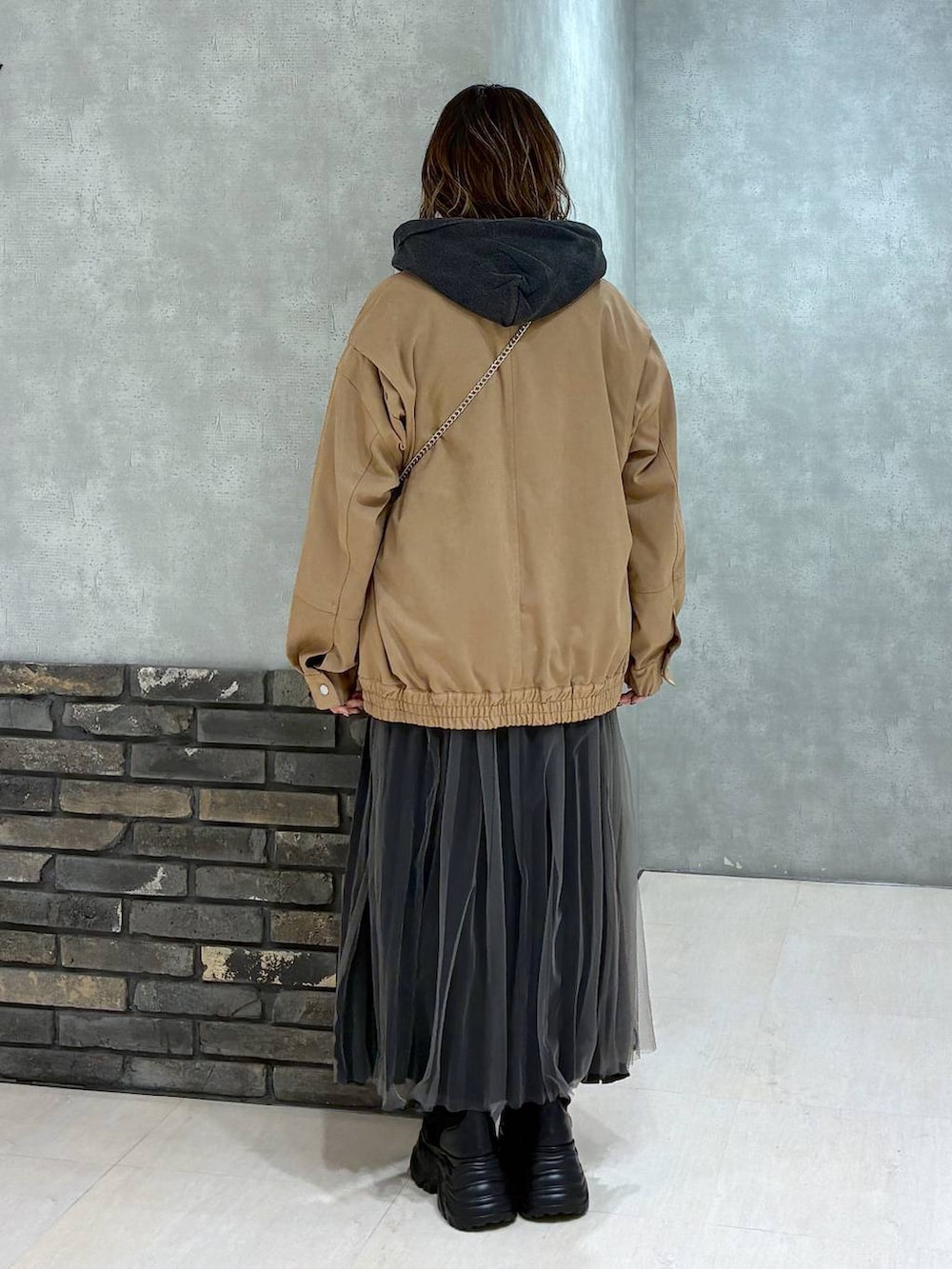 ブラック系のブーツ、イエロー系のブルゾン、ブラック系のパーカーを着用したレディースの秋コーディネートの4枚目の写真