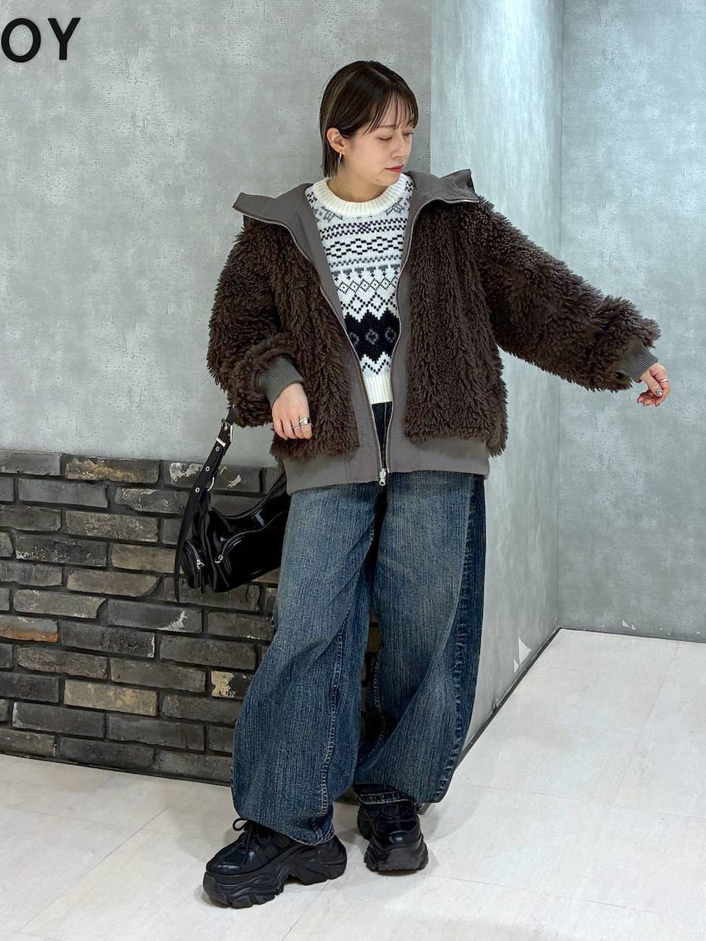 ブラック系のスニーカー、ブラウン系のブルゾン、ブラック系のショルダーバッグを着用したレディースの秋コーディネートの3枚目の写真