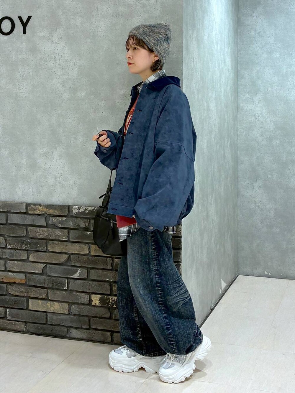 ホワイト系のスニーカー、ブラック系のボストンバッグ、レッド系のスウェットを着用したレディースの冬コーディネートの6枚目の写真