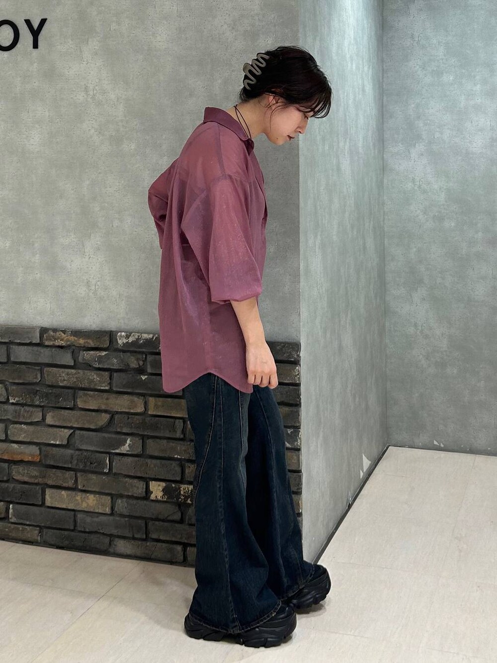 ブラック系のスニーカー、レッド系のシャツ/ブラウス、ブルー系のデニムパンツを着用したレディースの夏コーディネートの3枚目の写真