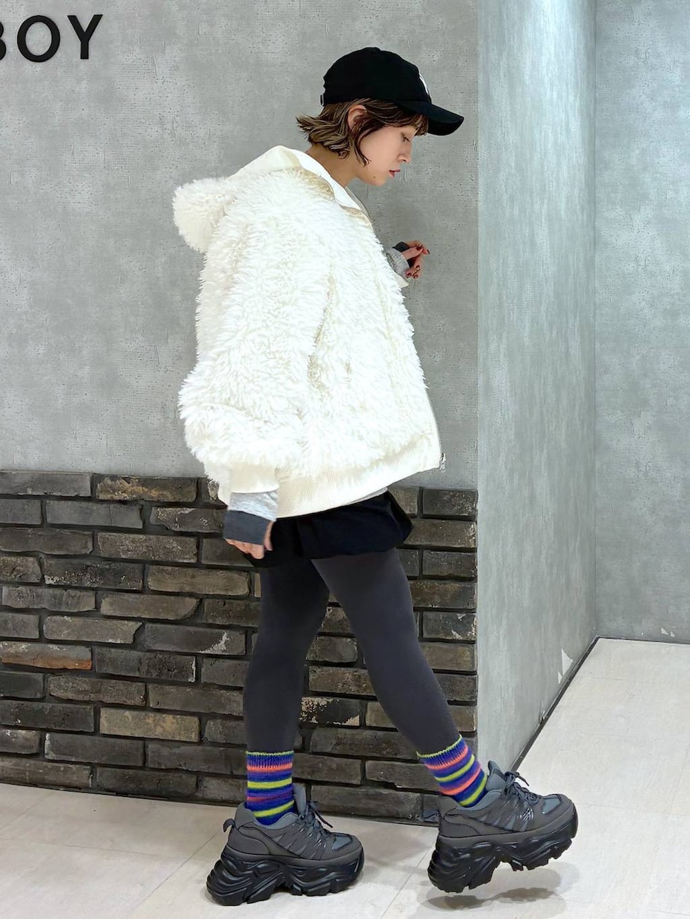 グレー系のスニーカー、ホワイト系のブルゾン、ブラック系のその他パンツを着用したレディースの冬コーディネートの4枚目の写真