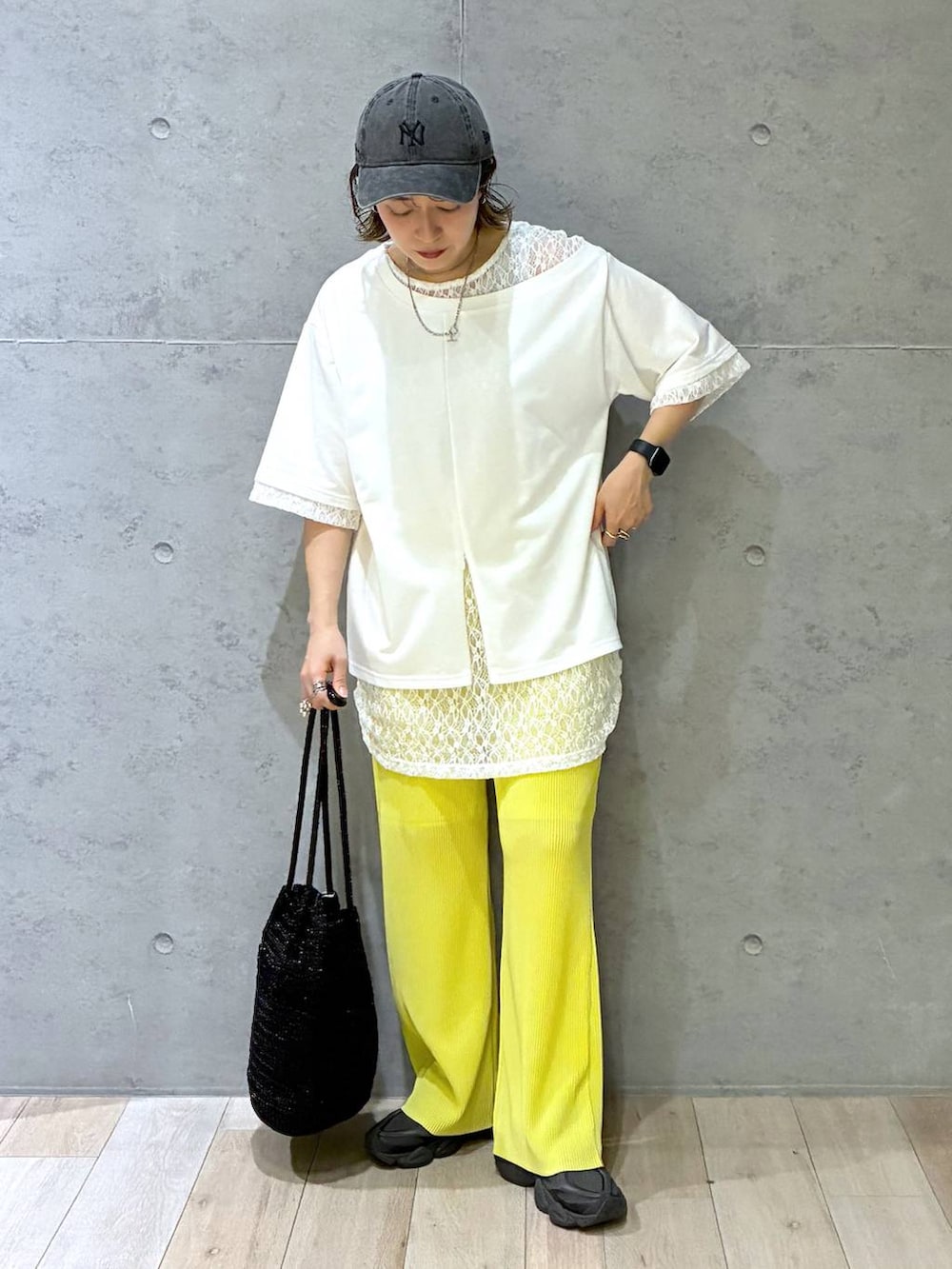 イエロー系のその他パンツ、ブラック系のショルダーバッグ、ホワイト系のTシャツ/カットソーを着用したレディースの春コーディネートの6枚目の写真