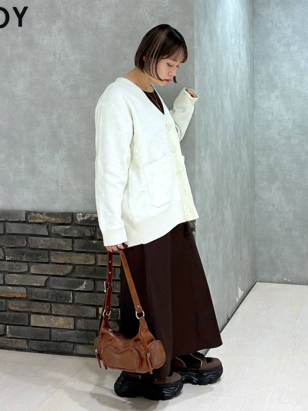 ブラウン系のブーツ、ブラウン系のニット/セーター、ブラウン系のスカートを着用したレディースの冬コーディネートの3枚目の写真