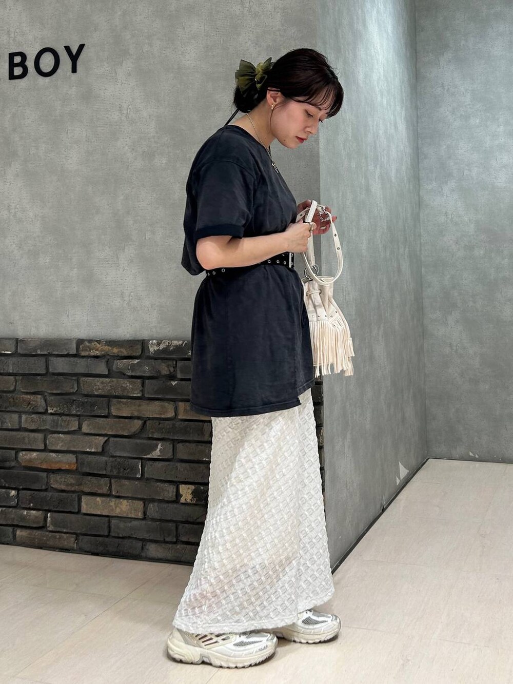 ホワイト系のスカート、ブラック系のTシャツ/カットソー、ホワイト系のショルダーバッグを着用したレディースの夏コーディネートの3枚目の写真