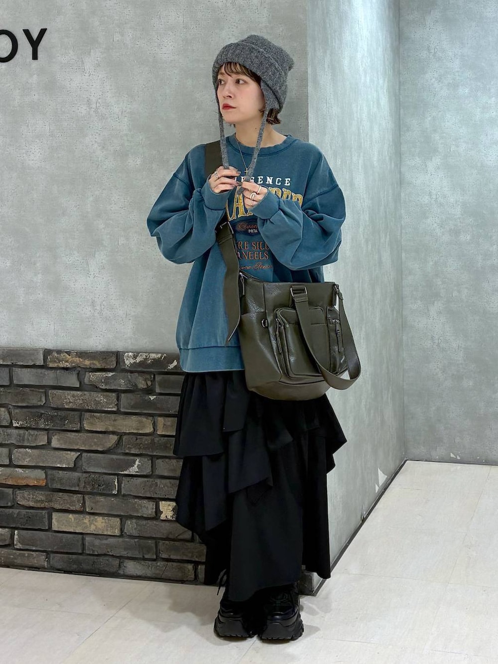 ブラック系のスニーカー、グリーン系のボストンバッグ、グリーン系のスウェットを着用したレディースの冬コーディネートの8枚目の写真