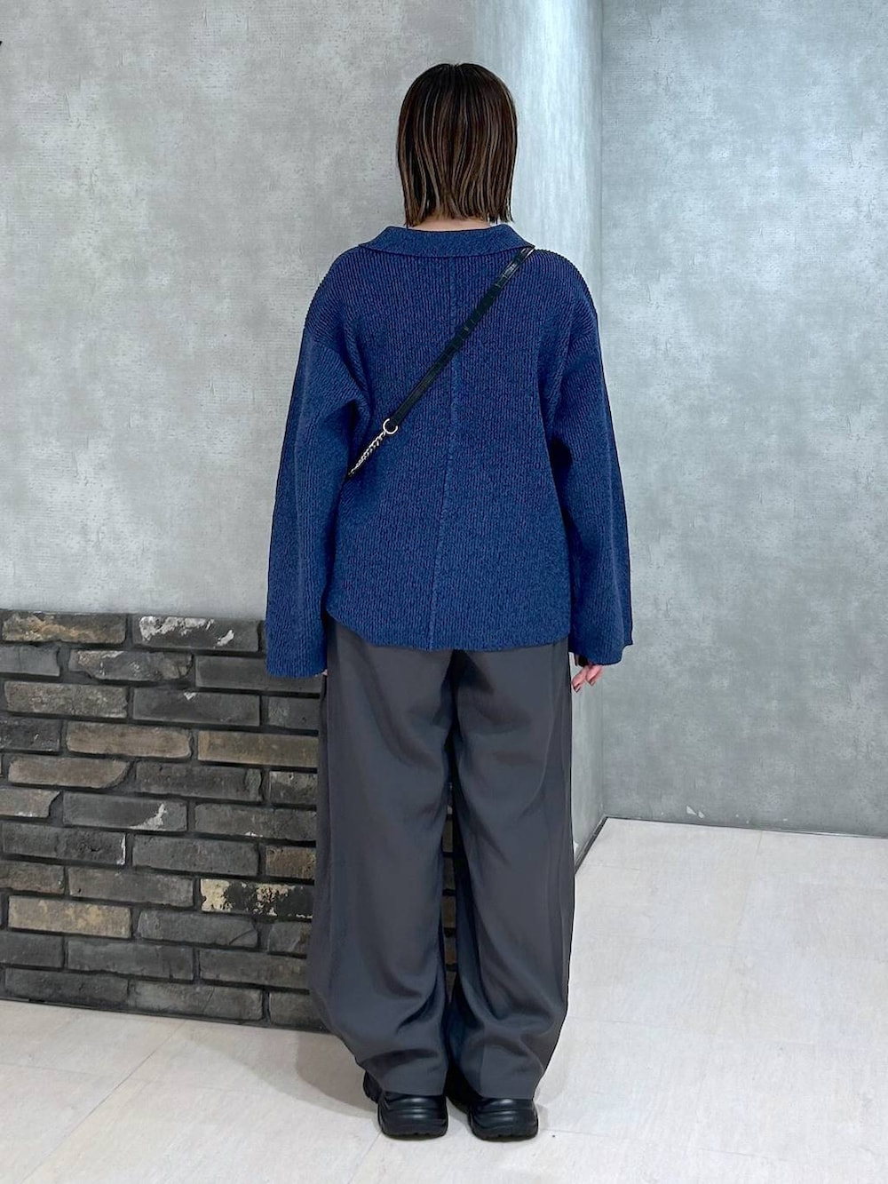 ブラック系のスニーカー、ブラック系のハンドバッグ、ブルー系のブルゾンを着用したレディースの秋コーディネートの3枚目の写真