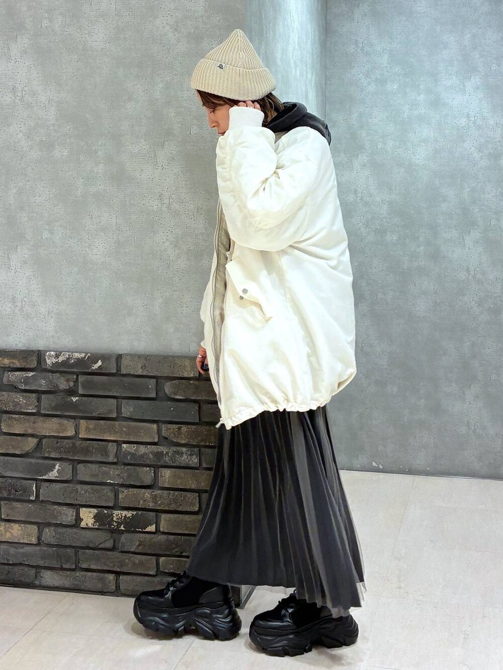 ブラック系のブーツ、ブラック系のパーカー、ホワイト系のブルゾンを着用したレディースの秋コーディネートの5枚目の写真