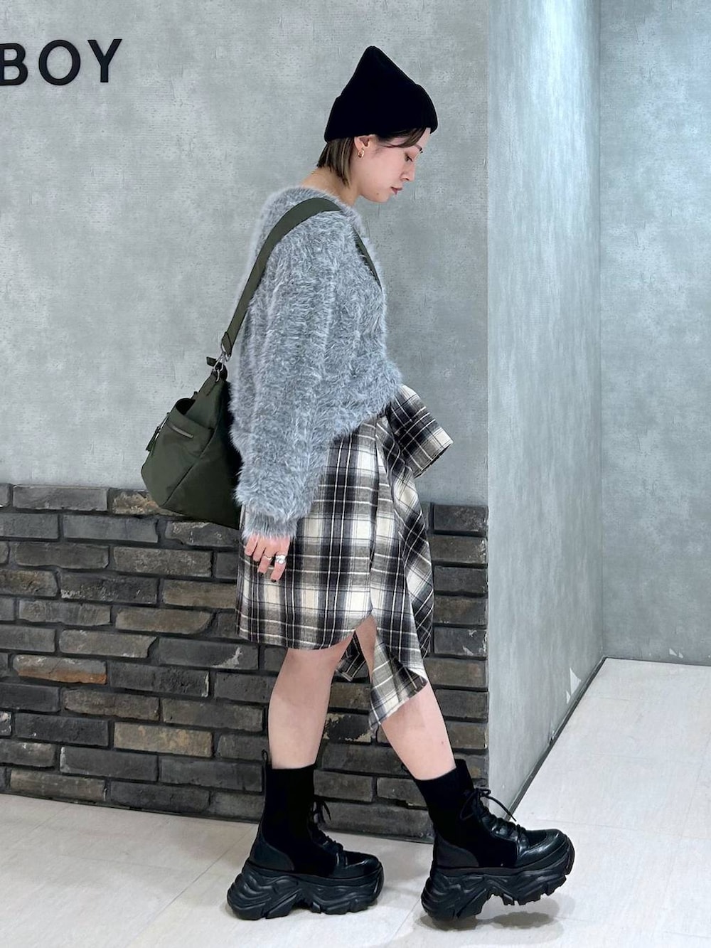 ブラック系のブーツ、グリーン系のボストンバッグ、ブラック系のその他パンツを着用したレディースの秋コーディネートの2枚目の写真