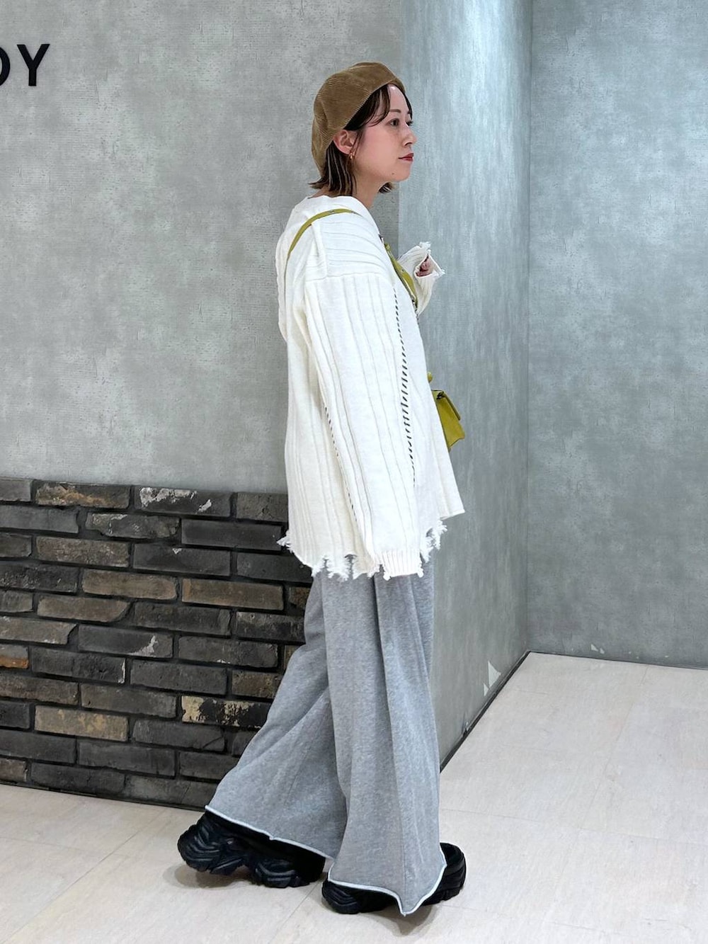 ブラック系のスニーカー、グレー系のスウェットパンツ、イエロー系のハンドバッグを着用したレディースの秋コーディネートの4枚目の写真