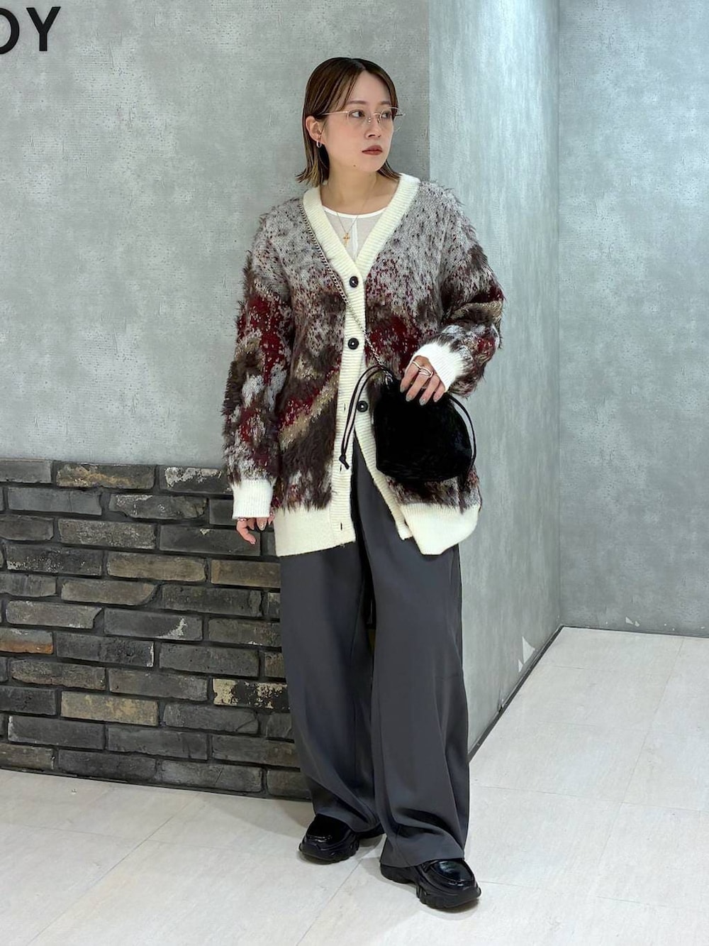 ホワイト系のTシャツ/カットソー、ホワイト系のカーディガン/ボレロ、グレー系のスラックスを着用したレディースの秋コーディネートの6枚目の写真