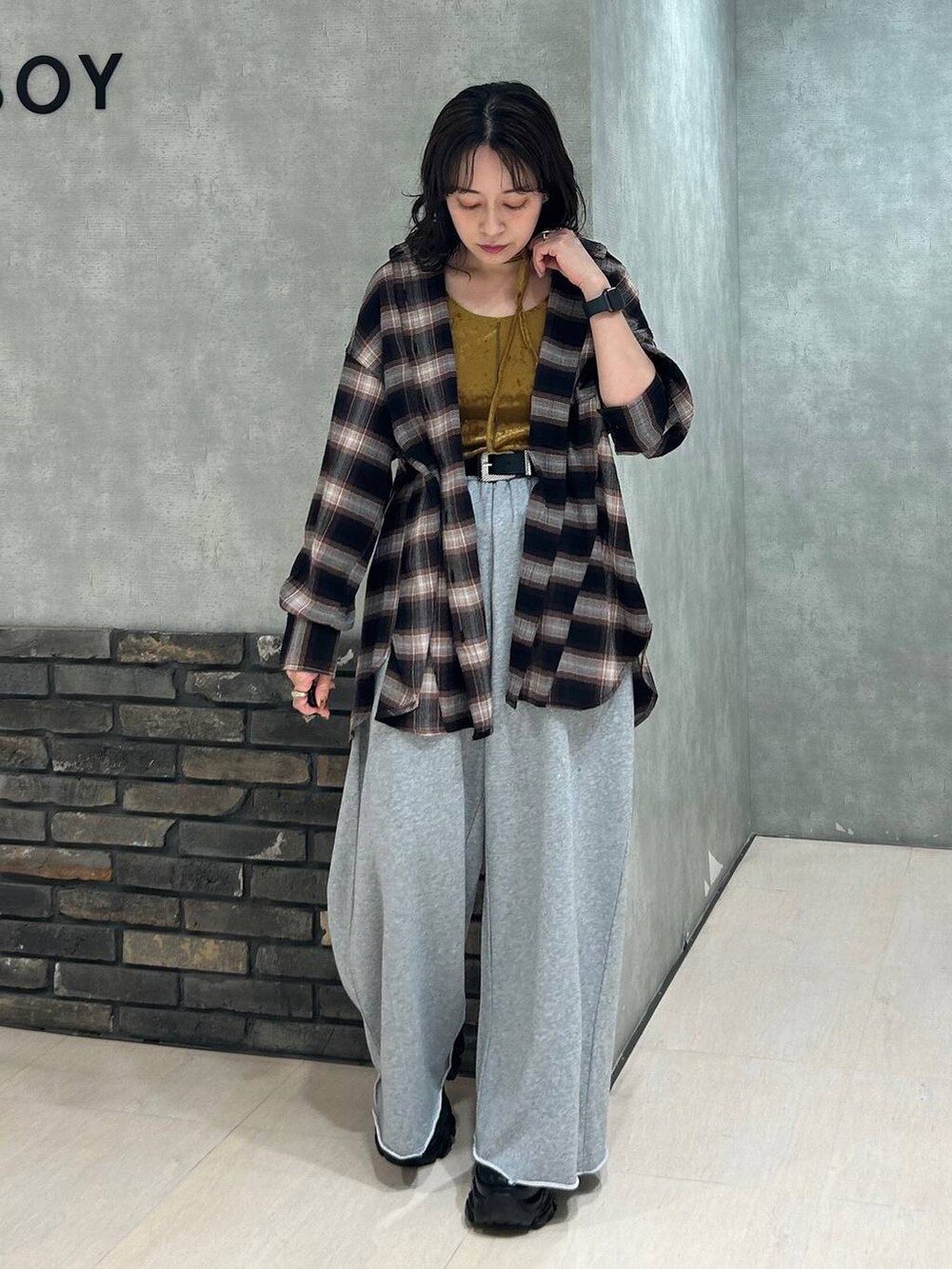 ブラック系のスニーカー、グレー系のスウェットパンツ、ブラウン系のシャツ/ブラウスを着用したレディースの秋コーディネートの3枚目の写真