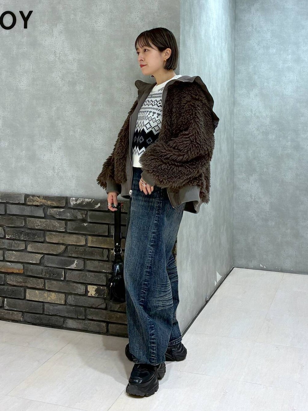 ブラック系のスニーカー、ブラウン系のブルゾン、ブラック系のショルダーバッグを着用したレディースの秋コーディネートの8枚目の写真