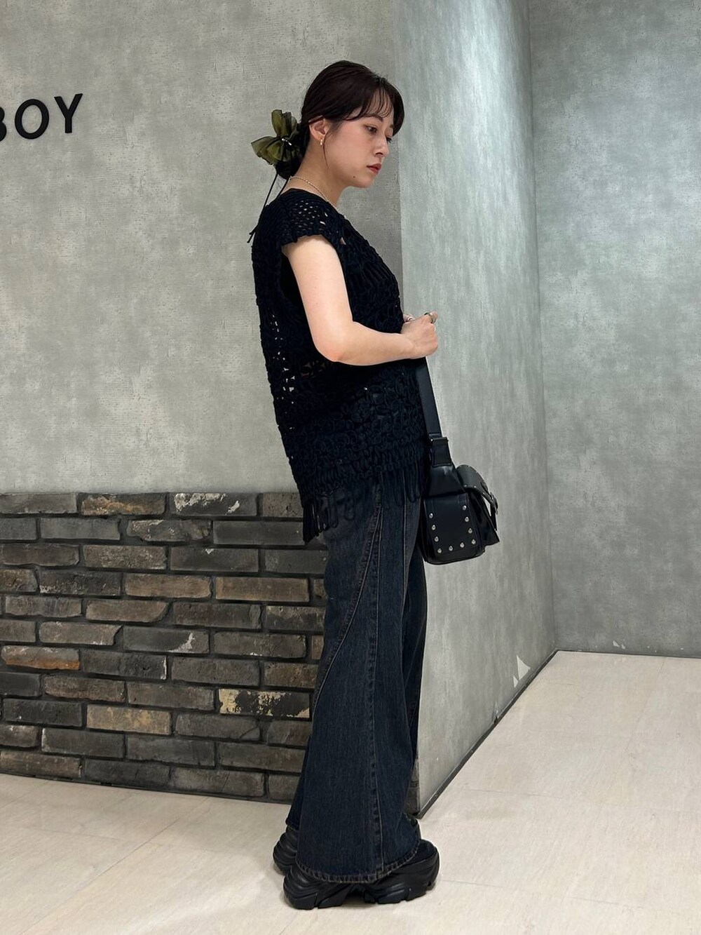 ブラック系のスニーカー、グレー系のタンクトップ、ブルー系のデニムパンツを着用したレディースの夏コーディネートの2枚目の写真