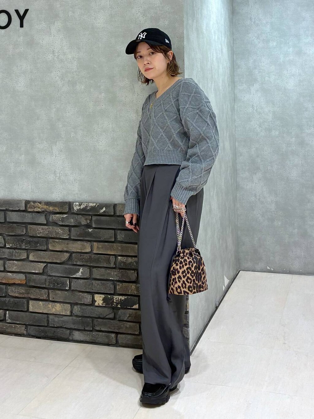 グレー系のスラックス、グレー系のニット/セーター、その他のハンドバッグを着用したレディースの秋コーディネートの6枚目の写真