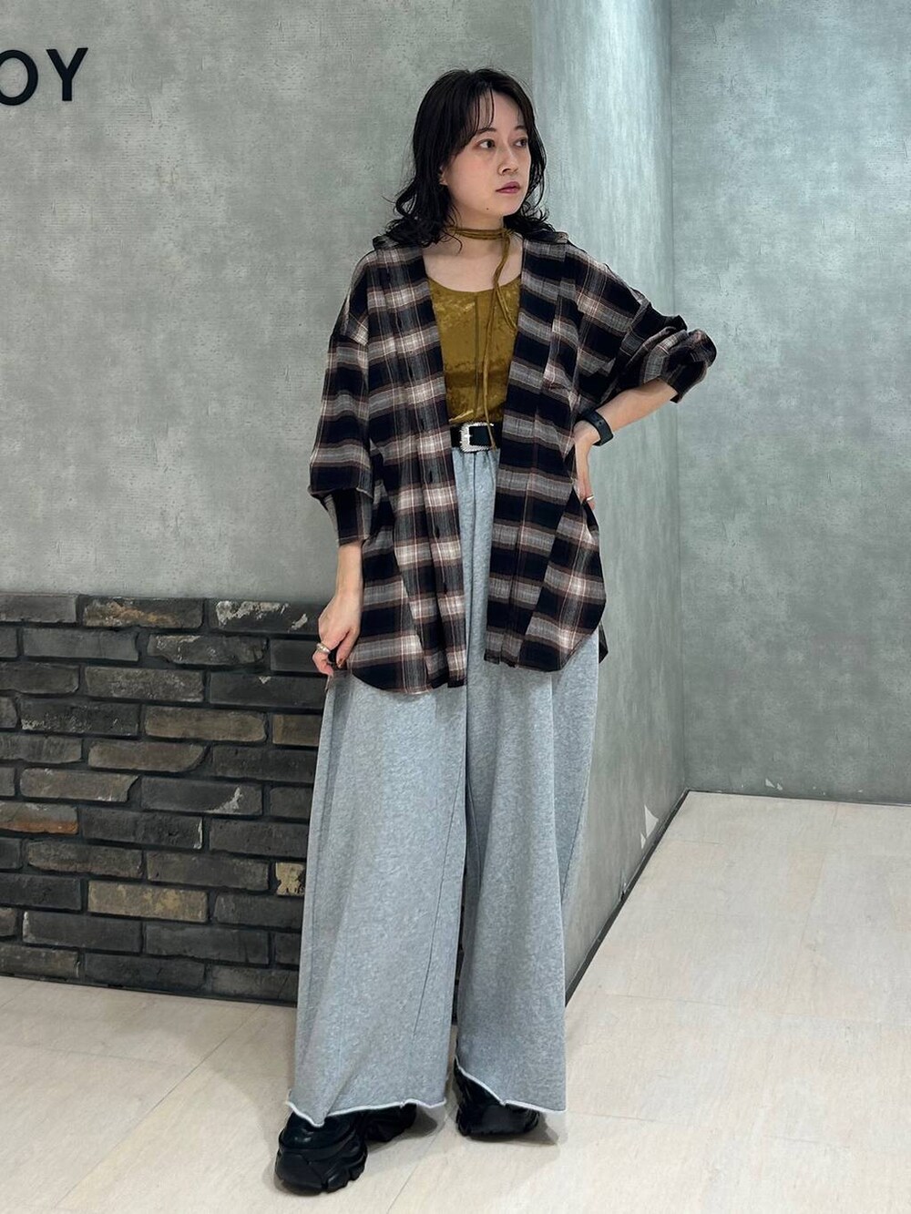 ブラック系のスニーカー、グレー系のスウェットパンツ、ブラウン系のシャツ/ブラウスを着用したレディースの秋コーディネートの7枚目の写真