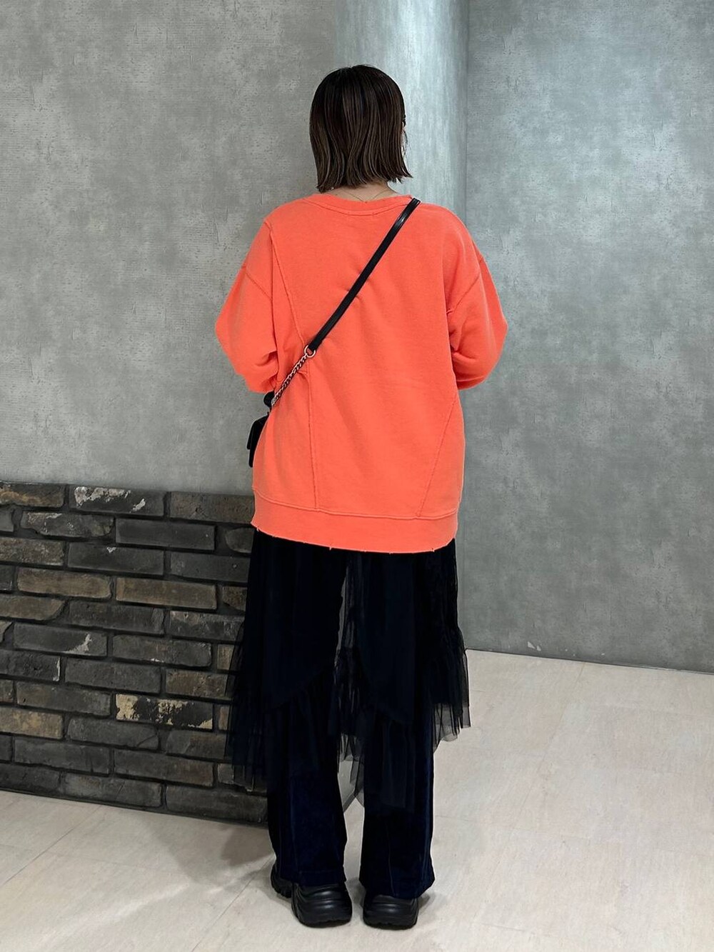 ブラック系のスニーカー、その他のハンドバッグ、ブルー系のその他パンツを着用したレディースの秋コーディネートの5枚目の写真