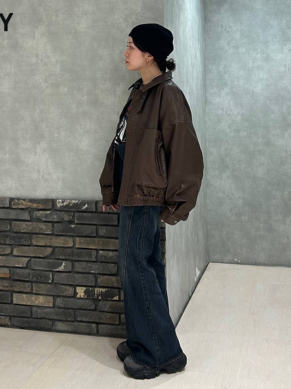 グレー系のスニーカー、ブルー系のデニムパンツ、ブラック系のTシャツ/カットソーを着用したレディースの秋コーディネートの6枚目の写真