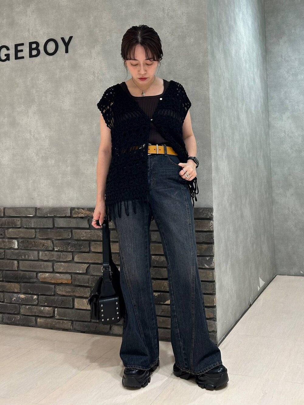 ブラック系のスニーカー、グレー系のタンクトップ、ブルー系のデニムパンツを着用したレディースの夏コーディネートの5枚目の写真