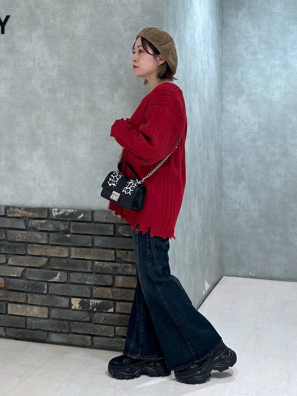 ブラック系のスニーカー、ブルー系のデニムパンツ、その他のハンドバッグを着用したレディースの秋コーディネートの5枚目の写真