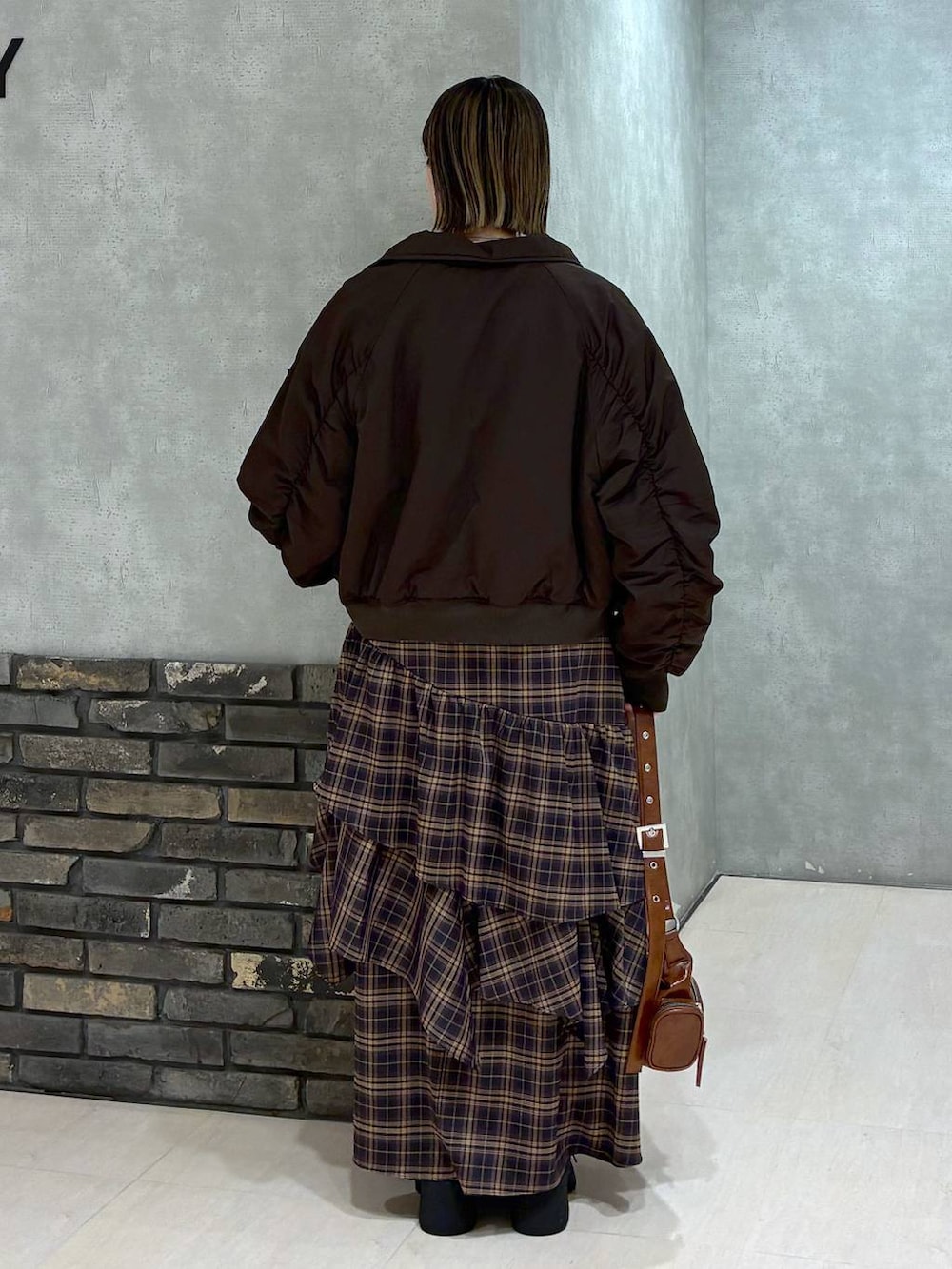 その他のブーツ、ブラウン系のスカート、ブラウン系のショルダーバッグを着用したレディースの冬コーディネートの6枚目の写真