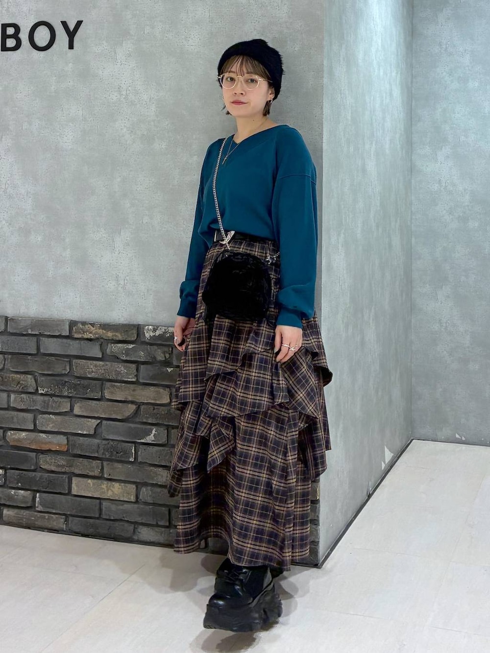 ブラック系のブーツ、ブラウン系のスカート、グリーン系のニット/セーターを着用したレディースの冬コーディネートの6枚目の写真