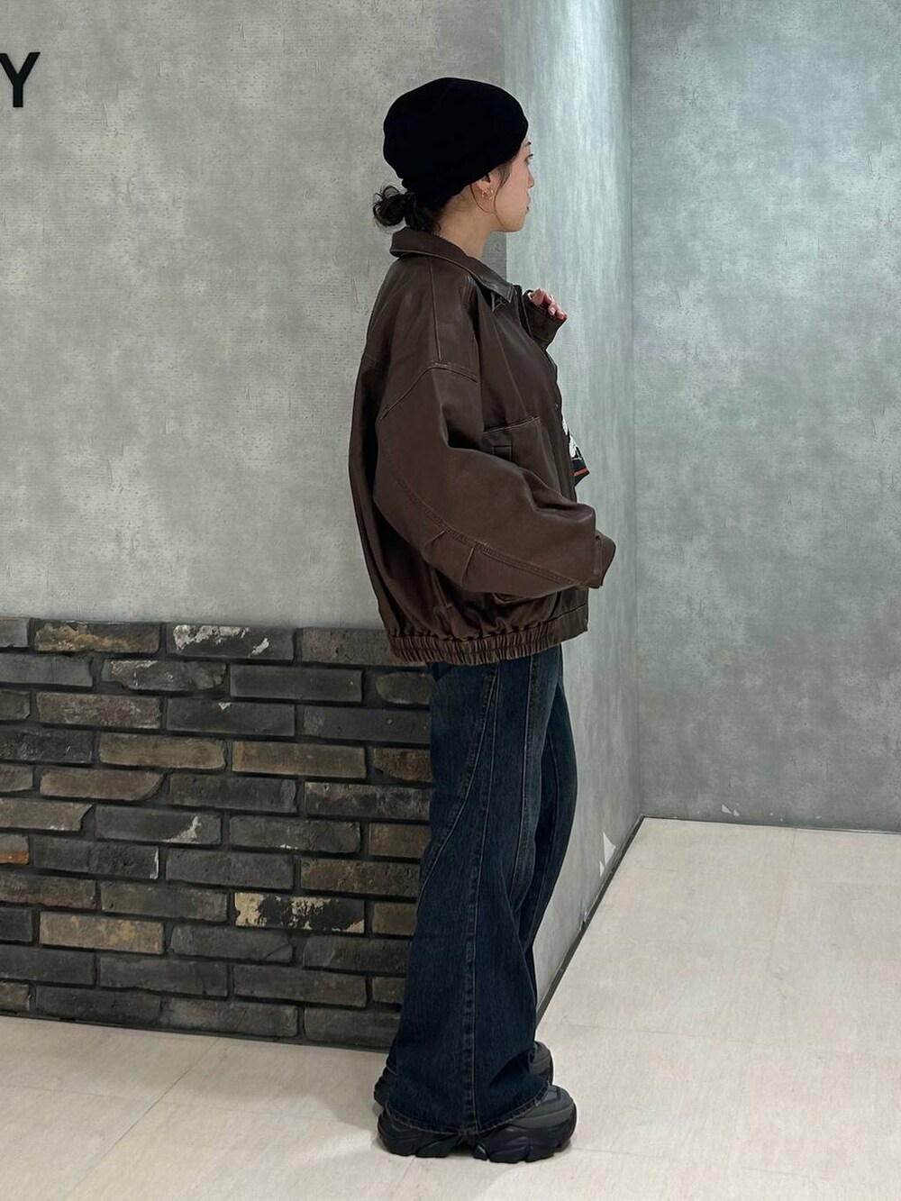 グレー系のスニーカー、ブルー系のデニムパンツ、ブラック系のTシャツ/カットソーを着用したレディースの秋コーディネートの2枚目の写真