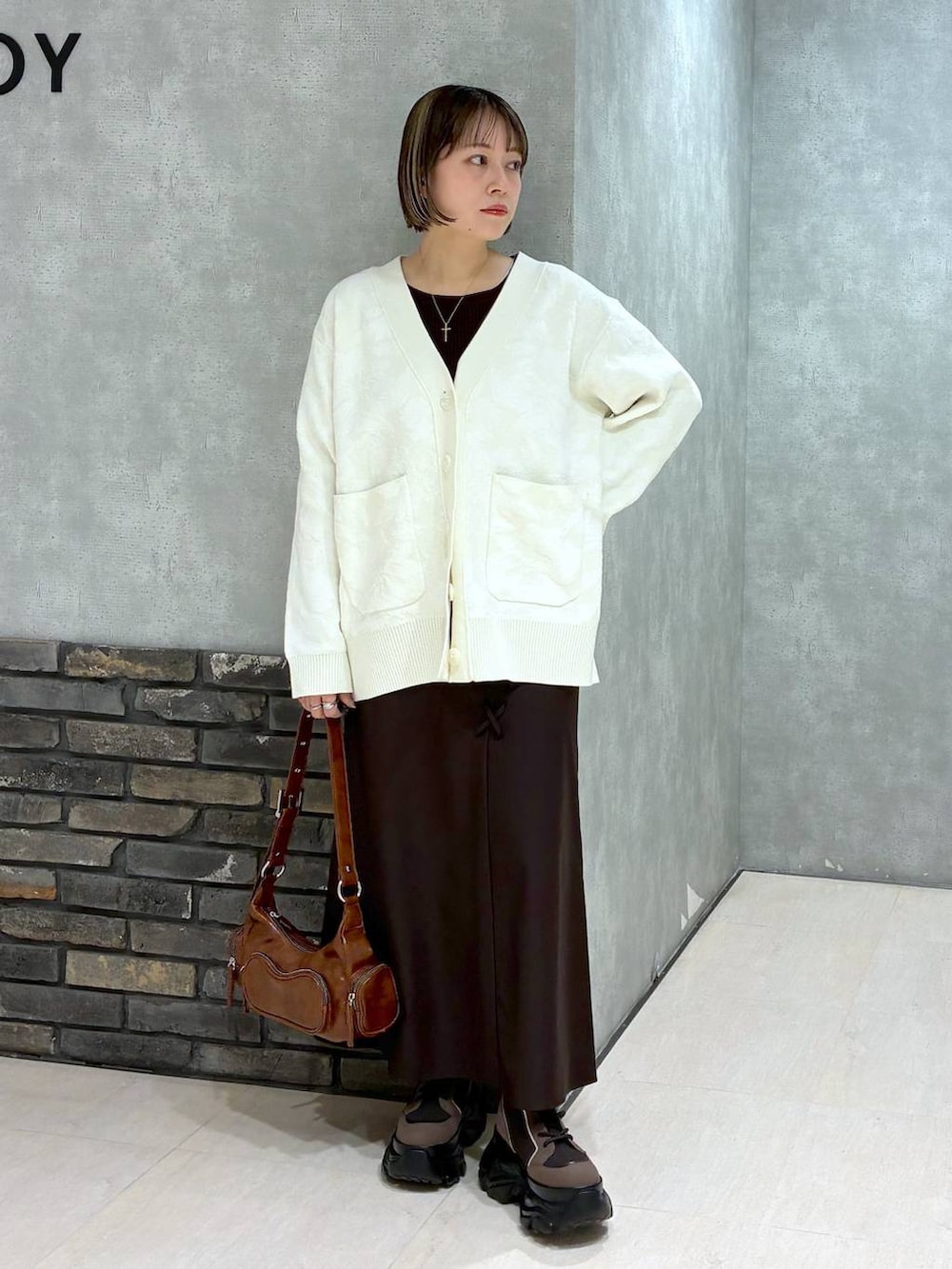 ブラウン系のブーツ、ブラウン系のニット/セーター、ブラウン系のスカートを着用したレディースの冬コーディネートの7枚目の写真