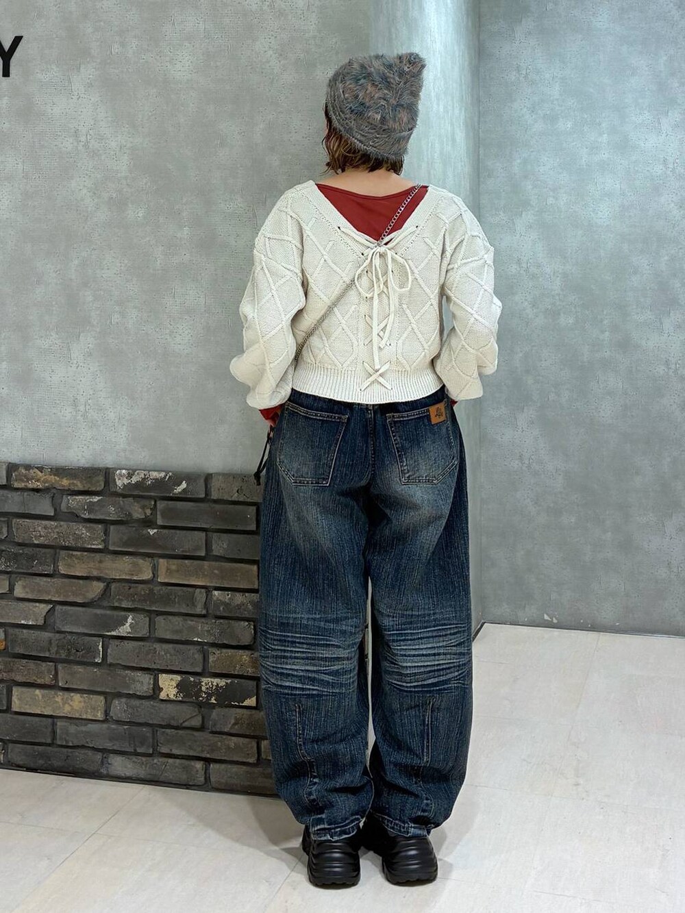 グレー系のスニーカー、ブルー系のデニムパンツ、ホワイト系のニット/セーターを着用したレディースの秋コーディネートの4枚目の写真